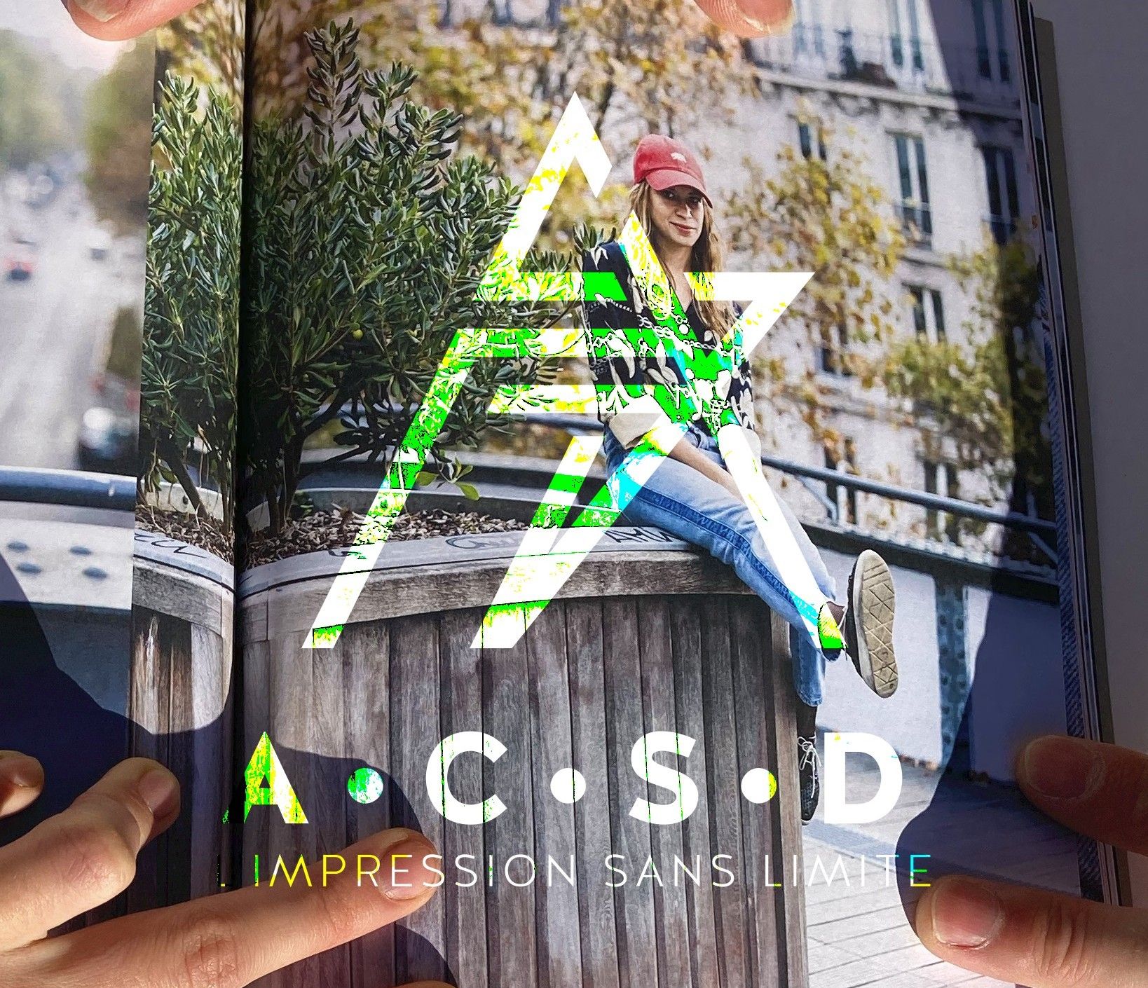 PHOTO magazine ouvert jeune fille assise en extérieur LOGO de la société impression numérique ACSD imression sans limite