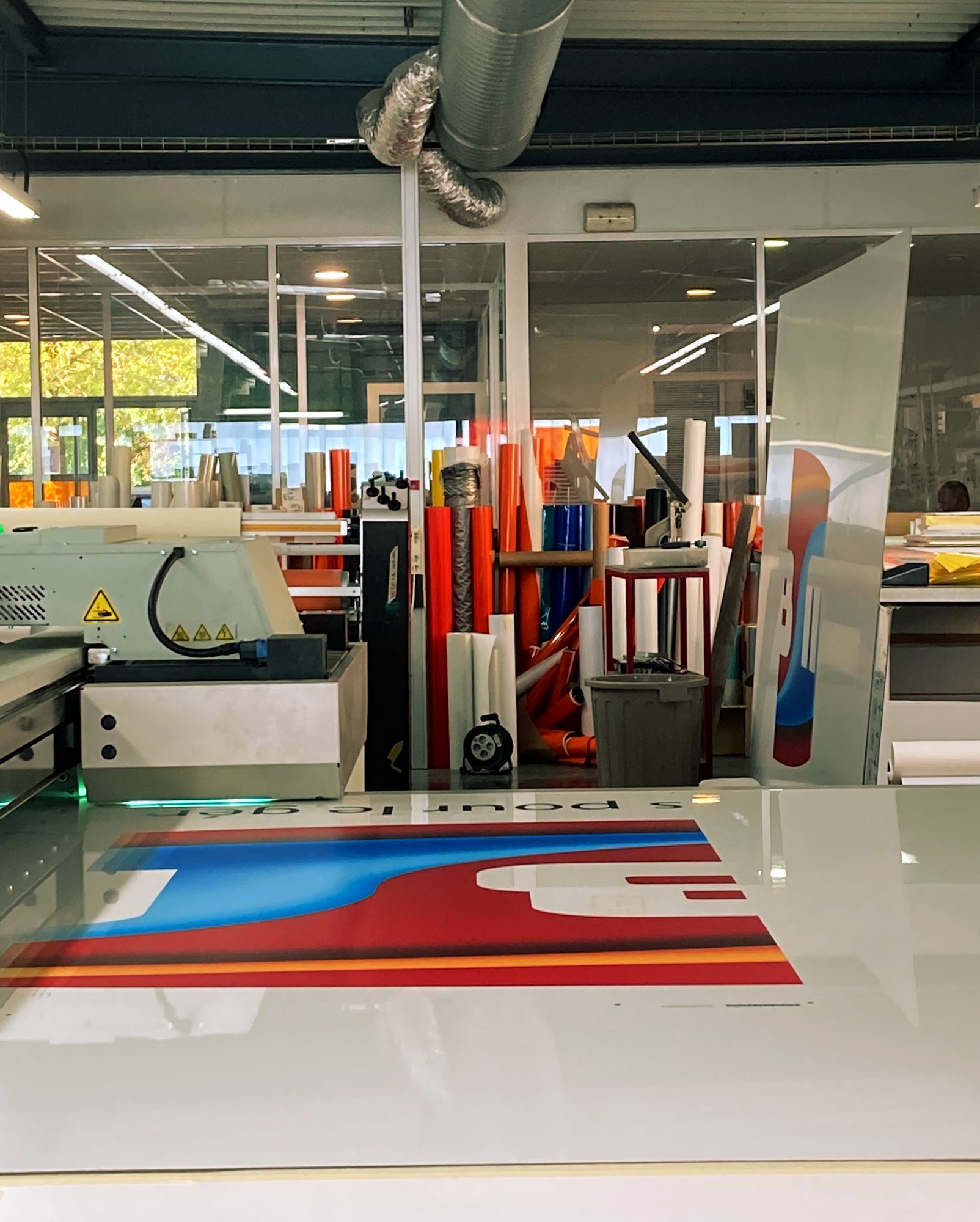 photo dans l'atelier d'ACSD de 2 plaques de dibond pour un grand panneau une debout et l'autre à plat sur machine pour impression et découpe